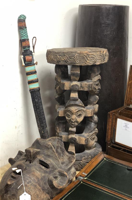 A Tribal mask, a carved pillar, a wooden umbrella stand and a tribal sword